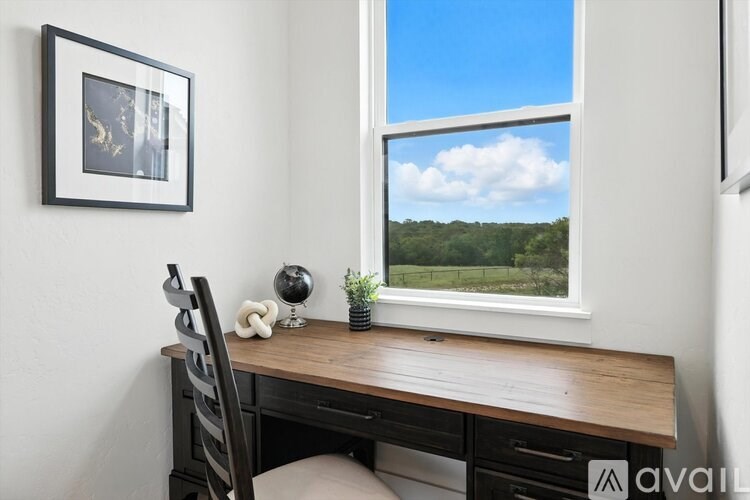 A desk with a chair and a globe on it with a window behind it.