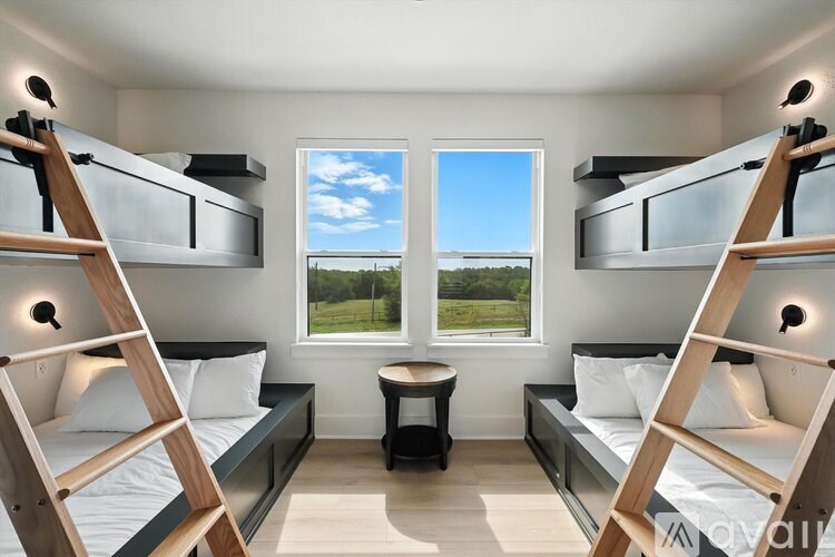 A room with two bunk beds and a small table.