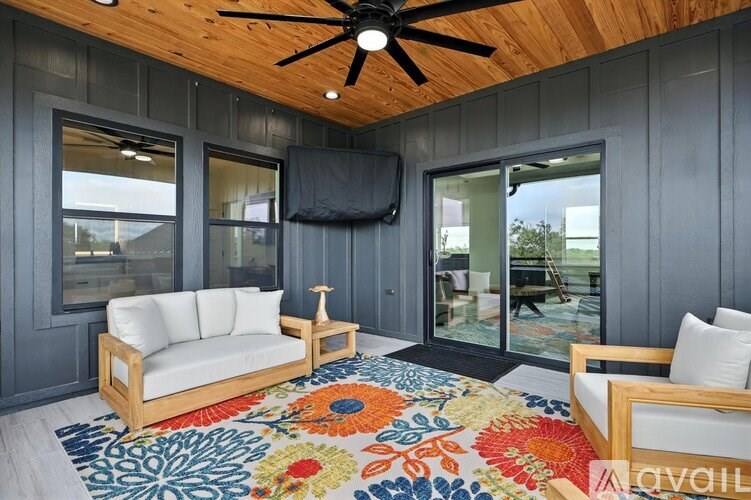 A living room with a white couch and a colorful rug.