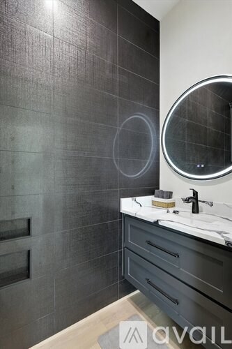 A bathroom with a round mirror and a sink.