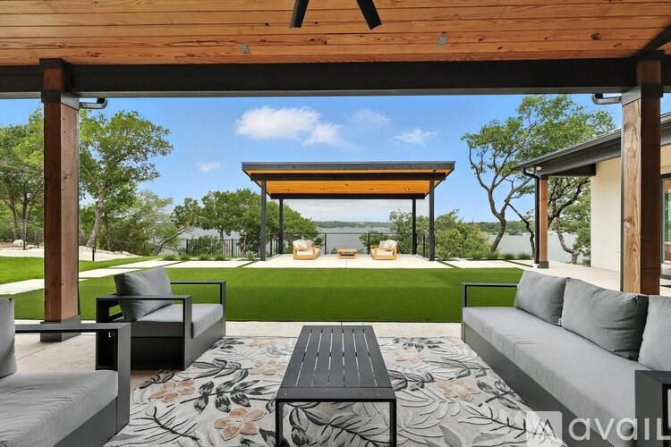 A wooden patio with a black table and couches.