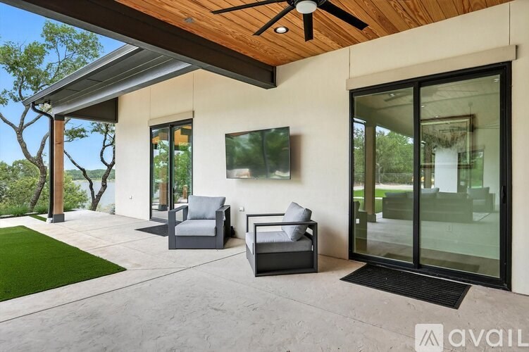 A modern outdoor patio area with two chairs and a table.