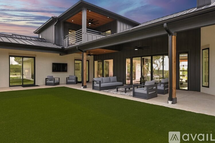 A modern house with a large backyard and a patio area.