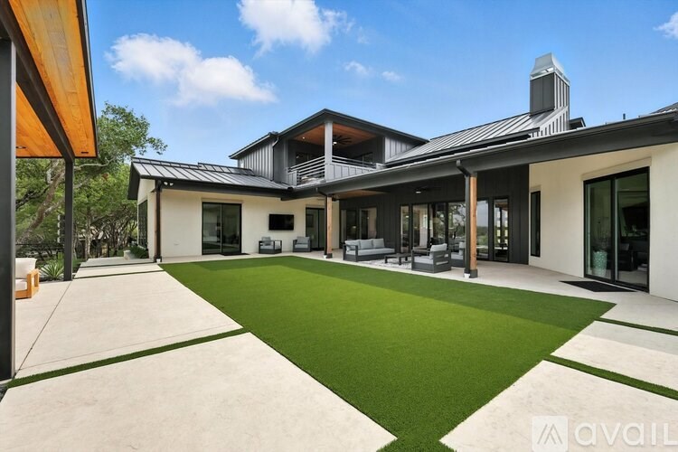 A modern house with a green lawn in front.