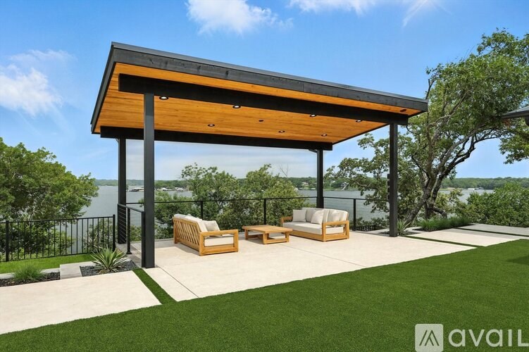 A wooden pergola with two couches underneath it.