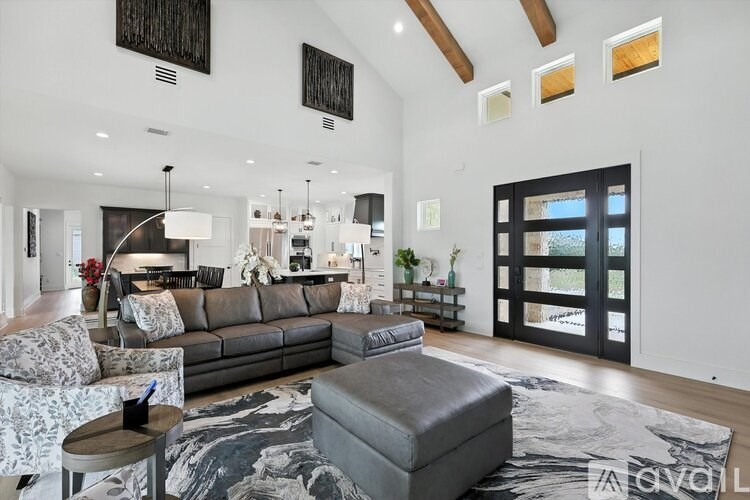 A modern living room with a grey sofa and a patterned rug.