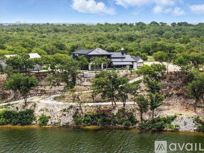 A house is situated on a cliff by a body of water.