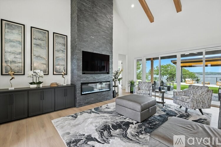 A modern living room with a fireplace and a large rug.