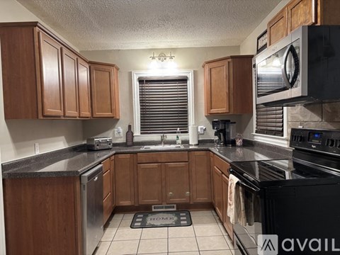 A kitchen with wooden cabinets and black appliances.