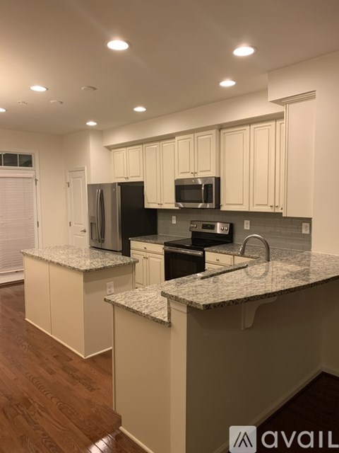 A kitchen with granite countertops and white cabinets.
