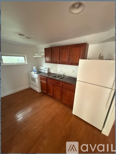 A kitchen with wooden cabinets and a white fridge.