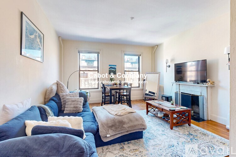 A living room with a blue couch and a fireplace.