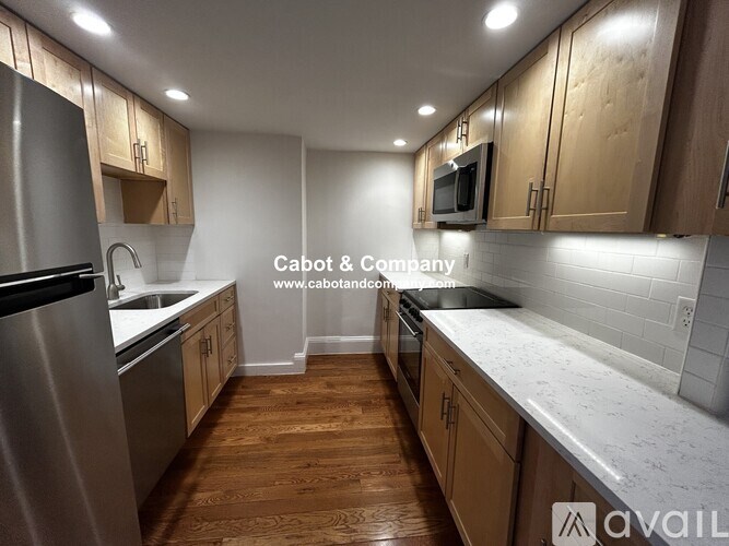A bedroom with a bed, nightstand, and window.