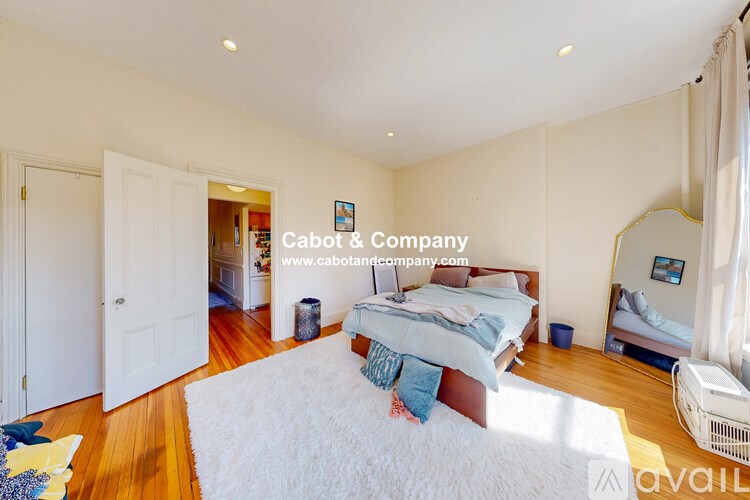 A bedroom with two beds and a white rug in the middle.
