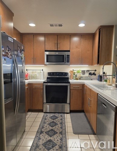 A kitchen with a refrigerator, oven, and microwave.