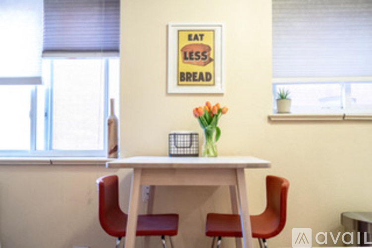 A poster on the wall of a room with a table and chairs.