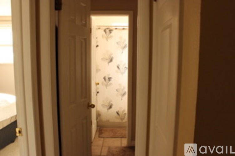 A hallway with a door covered in wallpaper.
