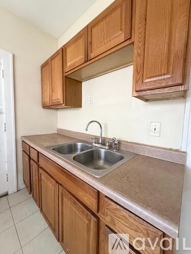 A kitchen with wooden cabinets and a stainless steel sink.