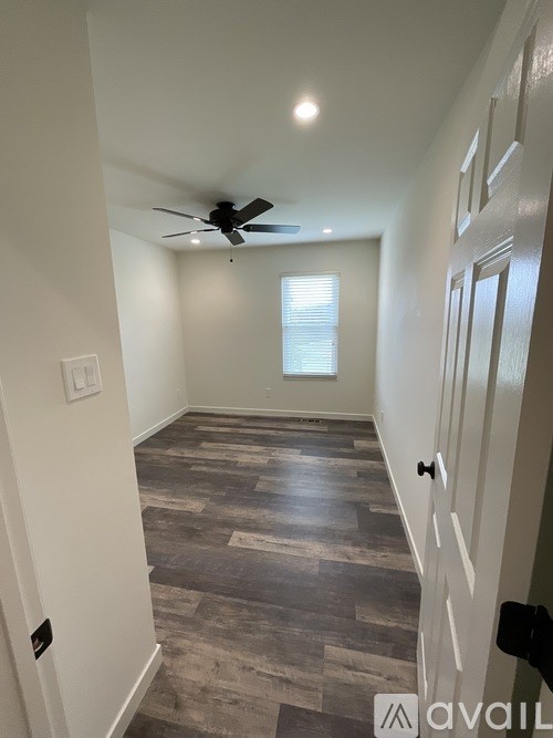 A hallway with a fan and a window.