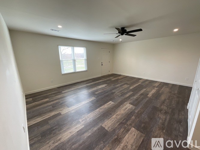 A room with wooden flooring and a ceiling fan.