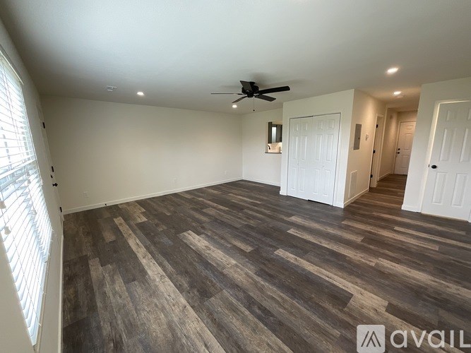A room with wooden flooring and a ceiling fan.
