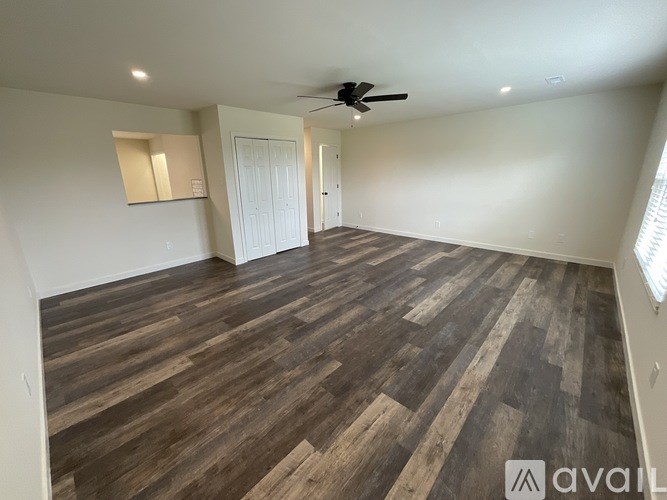 A room with wooden flooring and a ceiling fan.