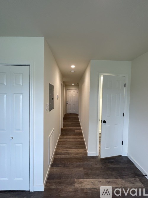 A hallway with white doors and a carpeted floor.