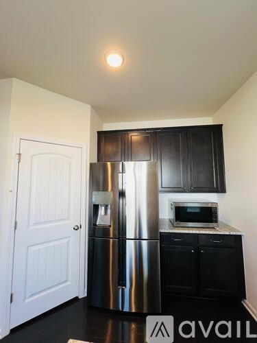 A kitchen with a stainless steel refrigerator and microwave.