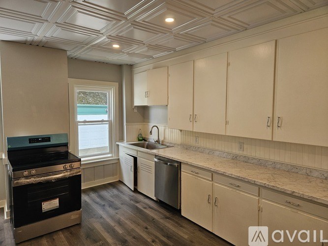 A kitchen with a stove, dishwasher, and cabinets.