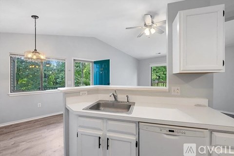 A kitchen with white cabinets and a blue door in the background.