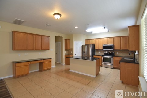 A kitchen with wooden cabinets and black countertops.