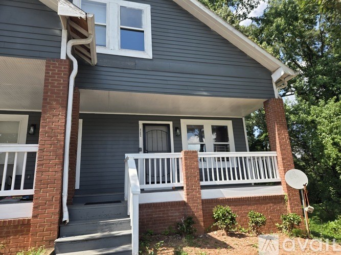A house with a grey siding and a white window.