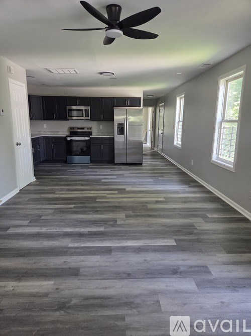 A spacious kitchen with a fan on the ceiling.