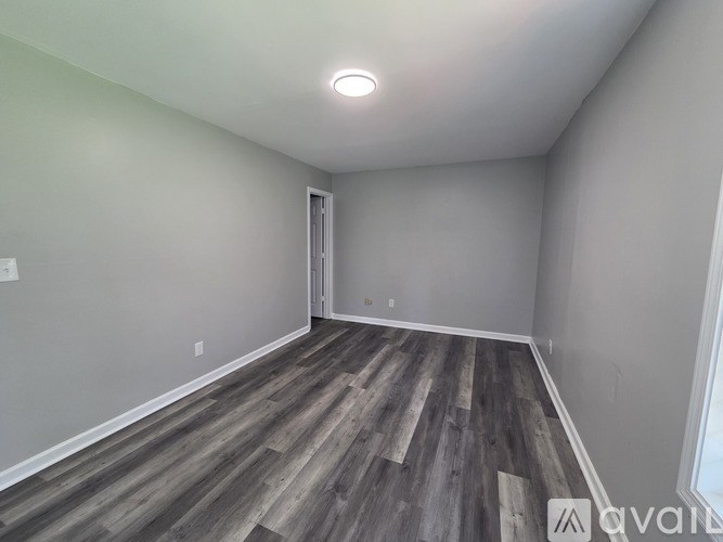 A room with wooden flooring and a white ceiling light.