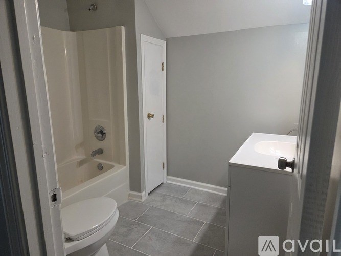 A bathroom with a toilet, sink, and bathtub.