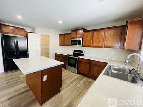 A kitchen with wooden cabinets and a white island.