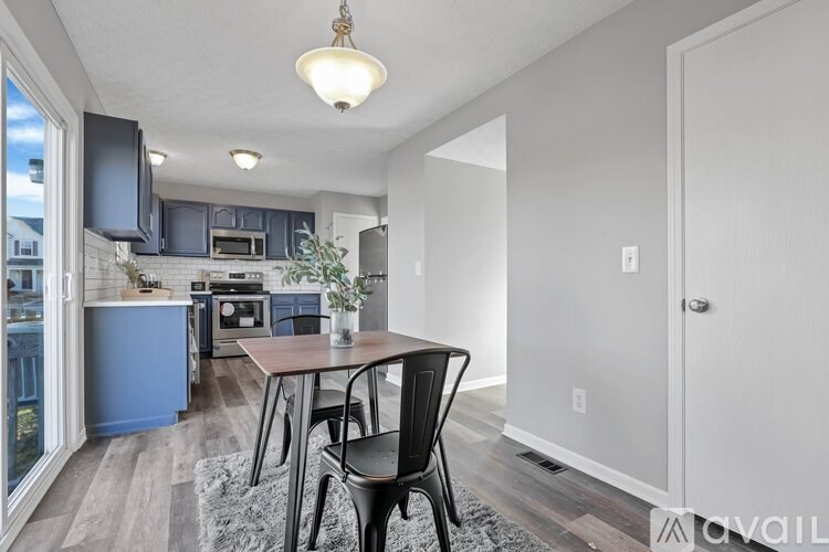 A kitchen with a table and chairs in the foreground.