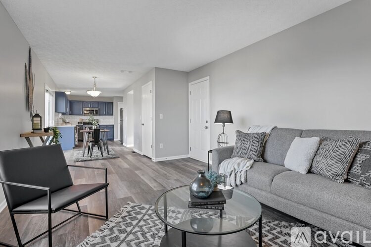 A living room with a grey couch and a glass coffee table.