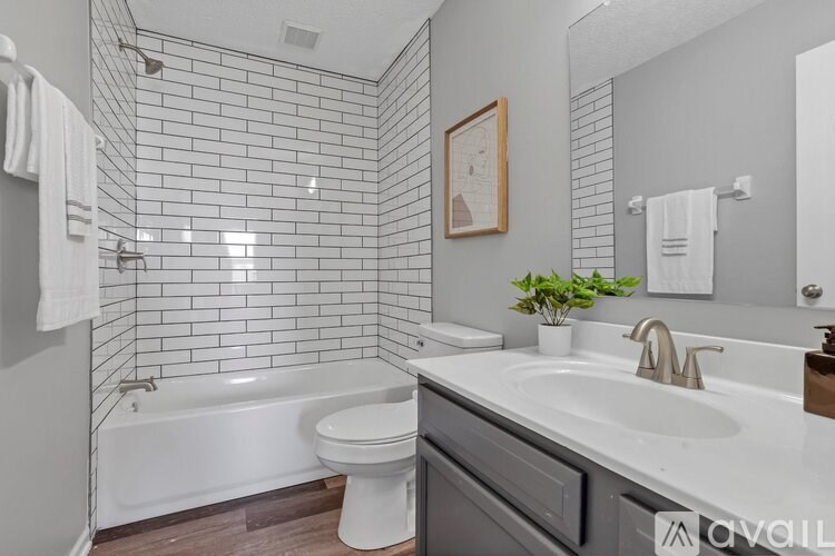A bathroom with a white tub, sink, and toilet.