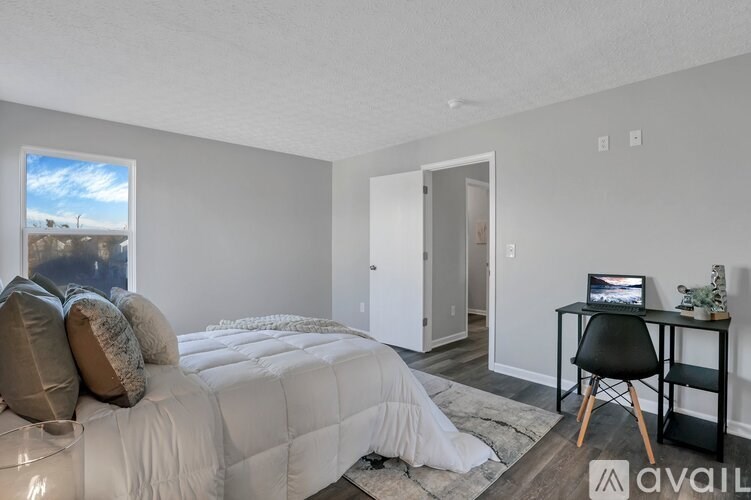 A bedroom with a bed, desk, and chair.