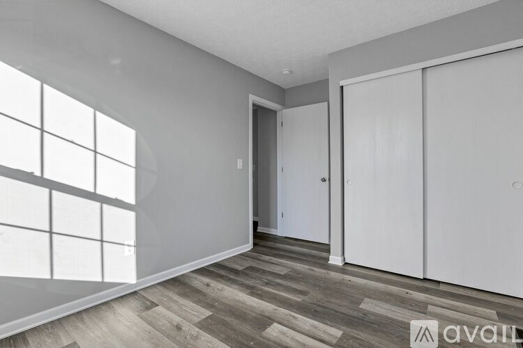 A room with a large window and a wooden floor.