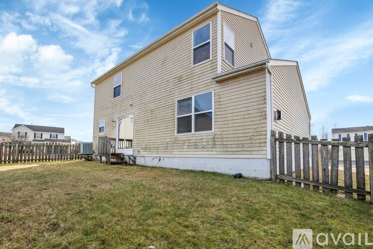 A two-story house with a wooden fence in front.