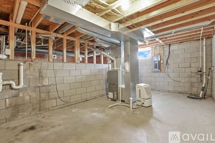 A room under construction with exposed wooden beams and ductwork.