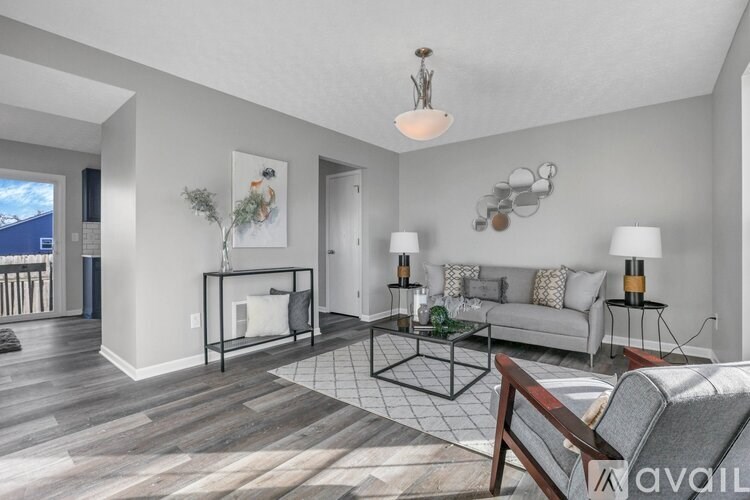 A living room with a white couch, a coffee table, and a large window.
