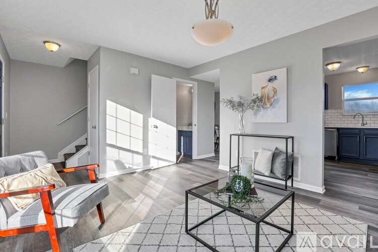 A living room with a sofa, a coffee table, and a painting on the wall.