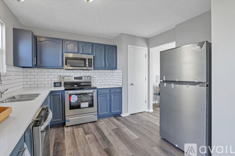 A kitchen with dark blue cabinets and stainless steel appliances.