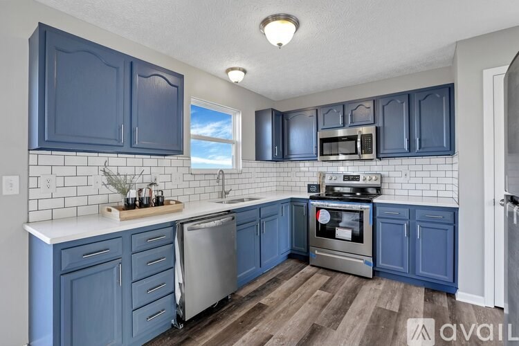A kitchen with blue cabinets and a white counter.