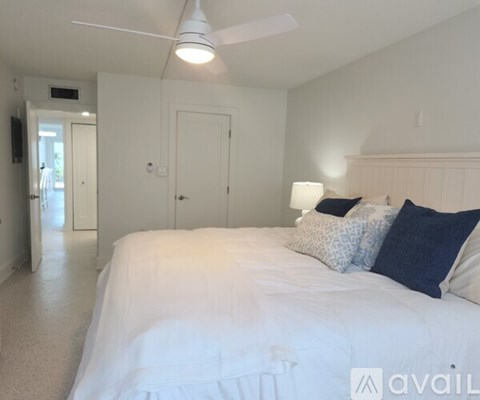 A bedroom with a large bed and a ceiling fan.