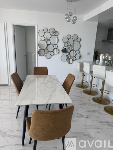 A dining room with a white table and brown chairs.