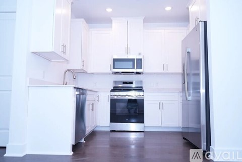 A kitchen with white cabinets and stainless steel appliances.